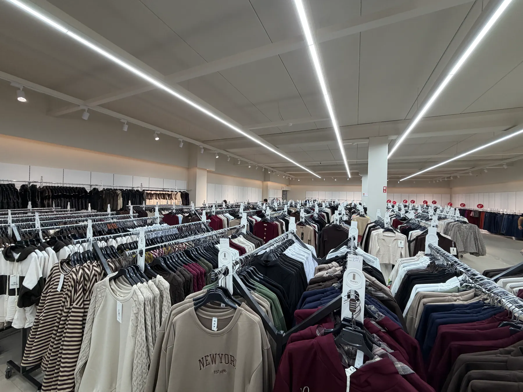 Interior da loja HUANG'S LUA CINTILANTE em Árvore: filas de araras com moda feminina